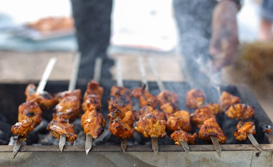 Skewers of marinated meat over glowing charcoal