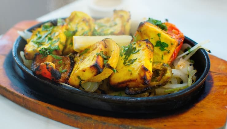 Paneer tikka on a sizzling iron platter