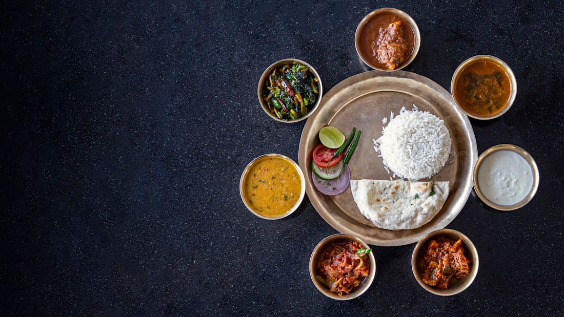 A brass thali surrounded by small katoris